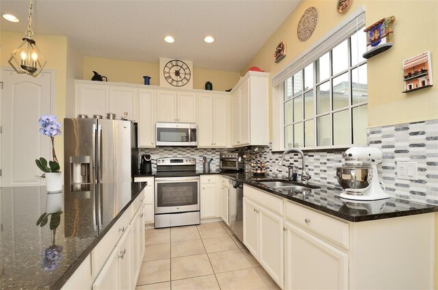 kitchen featuring dark stone countertops, sink, white cabinets, and appliances with stainless steel finishes