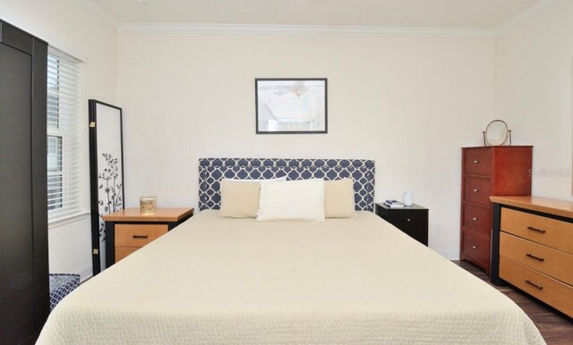 bedroom with dark wood-type flooring and ornamental molding