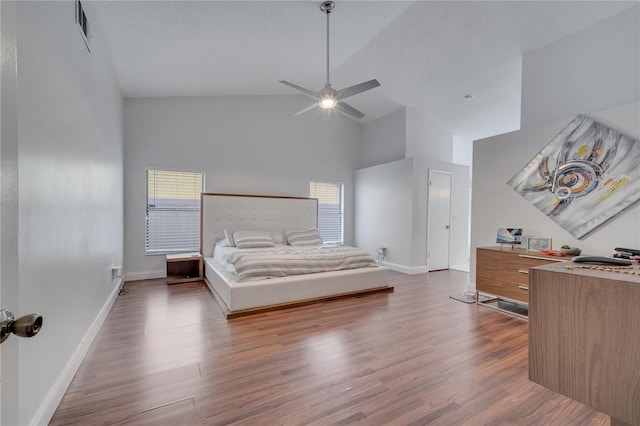 bedroom with ceiling fan, high vaulted ceiling, and dark hardwood / wood-style flooring