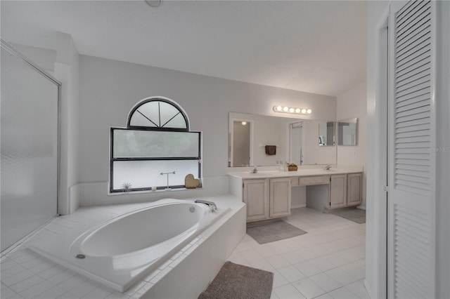 bathroom featuring tile patterned floors, vanity, and tiled tub