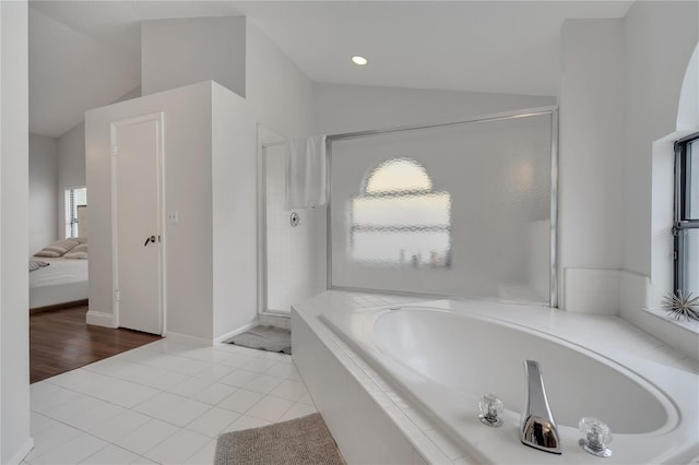 bathroom featuring separate shower and tub, lofted ceiling, and tile patterned flooring