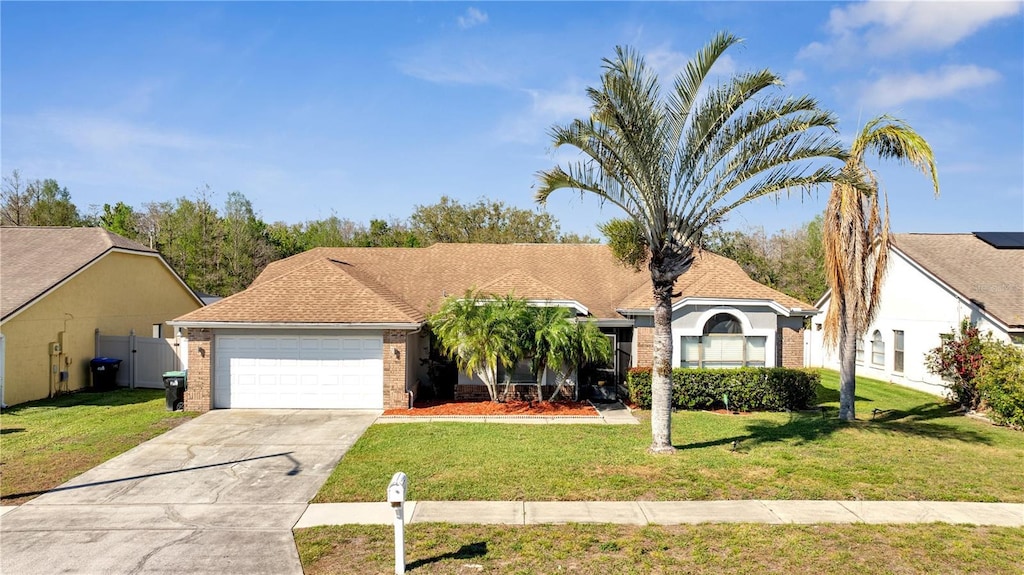 view of front of house with a front lawn, brick siding, driveway, and an attached garage