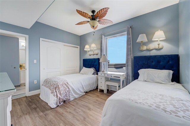 bedroom featuring light hardwood / wood-style flooring, ceiling fan, a closet, and ensuite bathroom