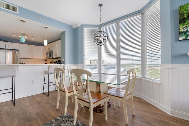 dining space with light hardwood / wood-style floors and a chandelier