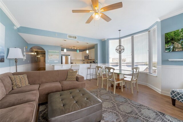 living room with ceiling fan, hardwood / wood-style flooring, and crown molding