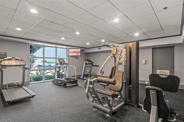 workout area featuring carpet floors and a paneled ceiling