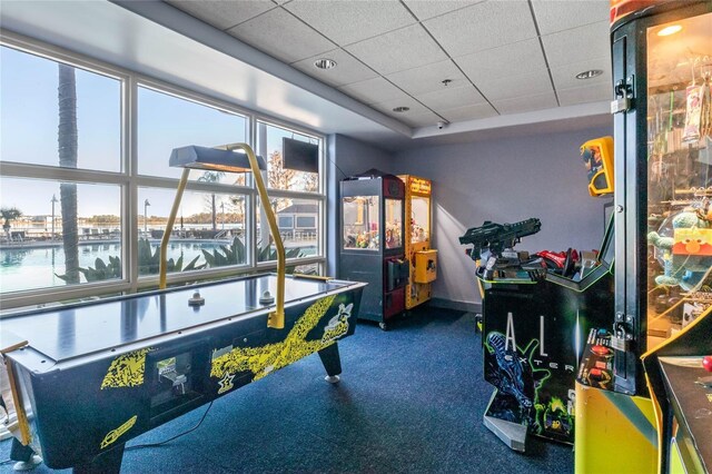 game room featuring a drop ceiling and a water view