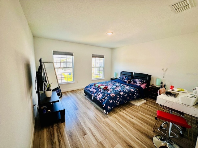 bedroom featuring hardwood / wood-style floors and a textured ceiling