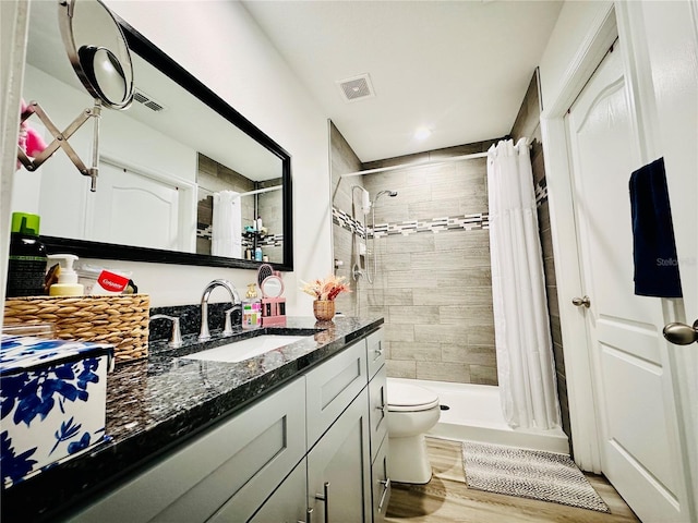 bathroom with toilet, vanity, a shower with shower curtain, and wood-type flooring