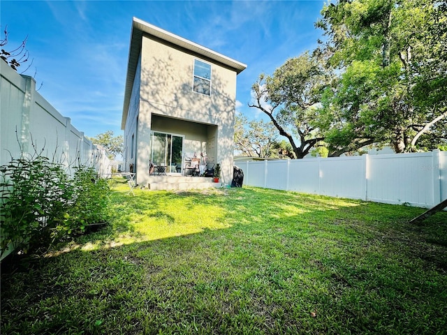 rear view of property featuring a lawn