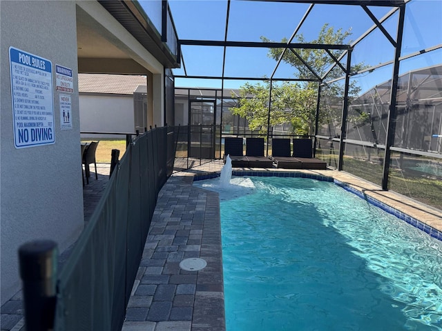 view of pool with pool water feature, a lanai, and a patio