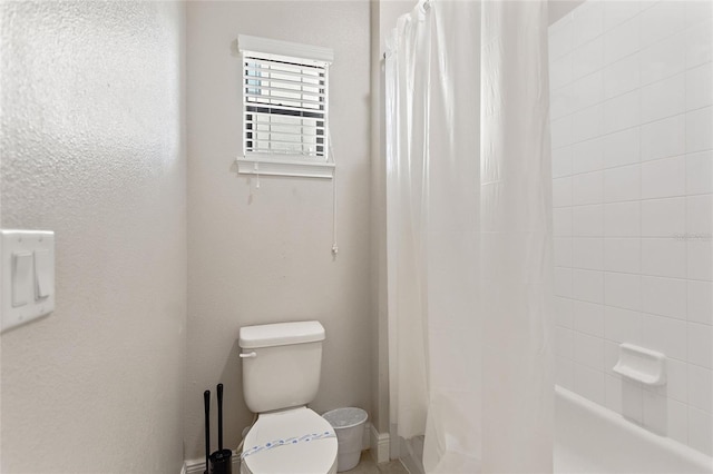 bathroom featuring shower / bath combo and toilet