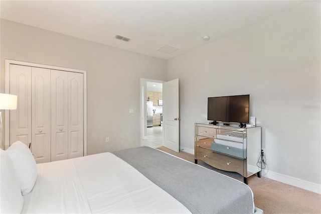 carpeted bedroom with stainless steel fridge and a closet