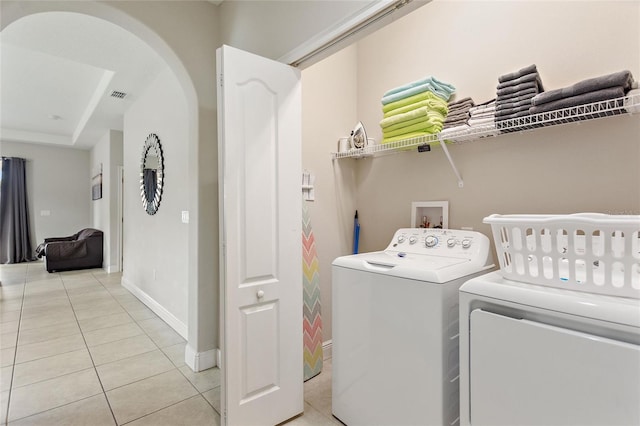 washroom with light tile patterned floors and washer and dryer