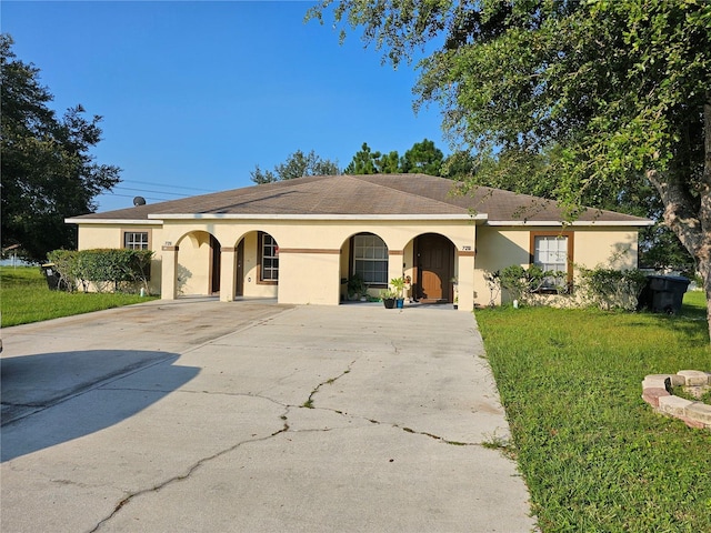 single story home with driveway, a front yard, and stucco siding