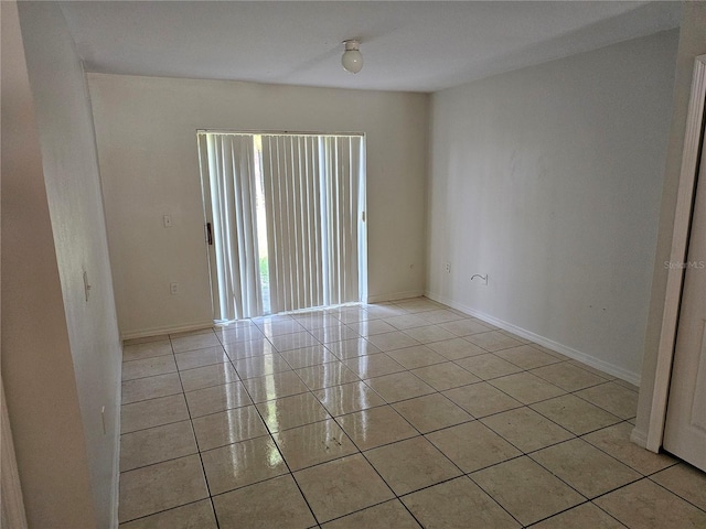 spare room featuring baseboards and light tile patterned floors