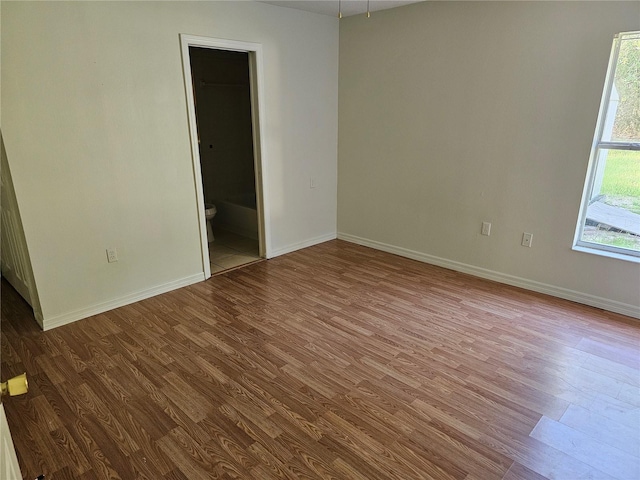 spare room featuring baseboards and wood finished floors