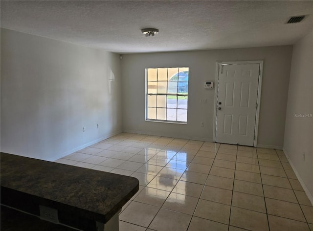 tiled foyer featuring a textured ceiling