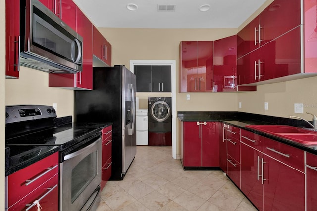 kitchen featuring washer / clothes dryer, stainless steel appliances, and sink