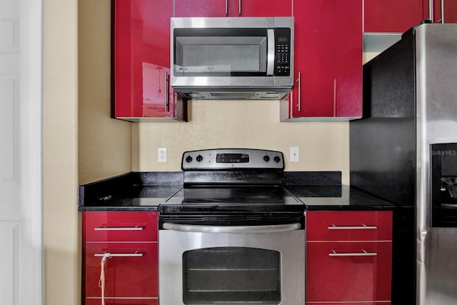 kitchen featuring appliances with stainless steel finishes and dark stone counters