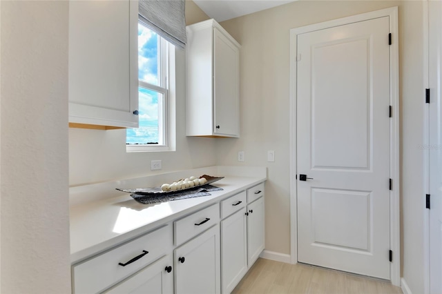 kitchen with white cabinets and light hardwood / wood-style flooring