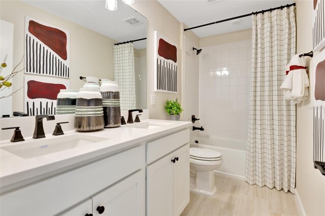 full bathroom with shower / bath combination with curtain, vanity, and toilet