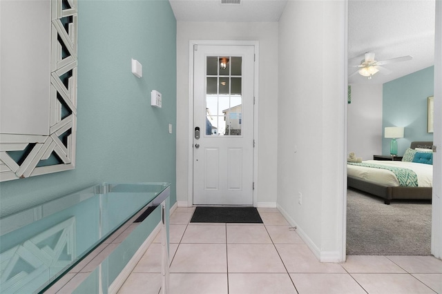 foyer entrance with ceiling fan and light tile patterned flooring