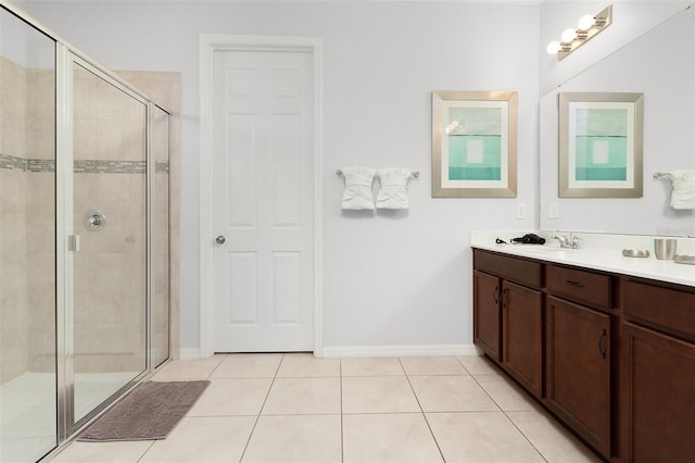 full bathroom with tile patterned flooring, a stall shower, vanity, and baseboards