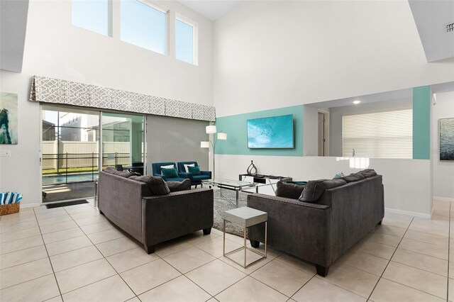 living room with light tile patterned floors and a towering ceiling