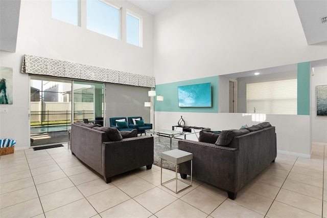 living area featuring light tile patterned floors, visible vents, and baseboards