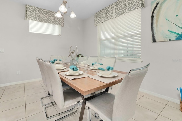 dining area featuring light tile patterned floors, a chandelier, and baseboards