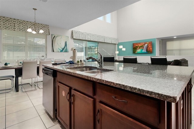 kitchen featuring light tile patterned flooring, sink, an inviting chandelier, decorative light fixtures, and stainless steel dishwasher