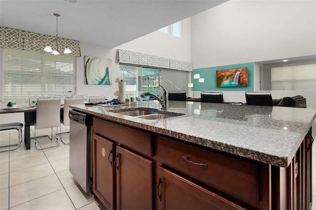 kitchen with an island with sink, a sink, open floor plan, light tile patterned flooring, and dishwasher