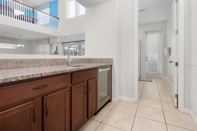 kitchen with sink, light tile patterned floors, a healthy amount of sunlight, and dishwasher