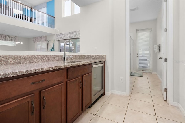 kitchen with visible vents, a sink, stainless steel dishwasher, light tile patterned flooring, and light countertops