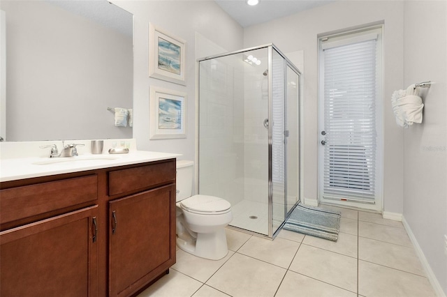 bathroom with a shower with door, toilet, vanity, and tile patterned floors