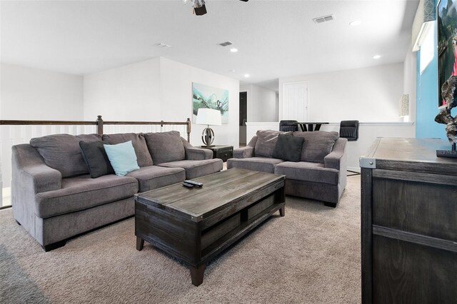 carpeted living room with ceiling fan