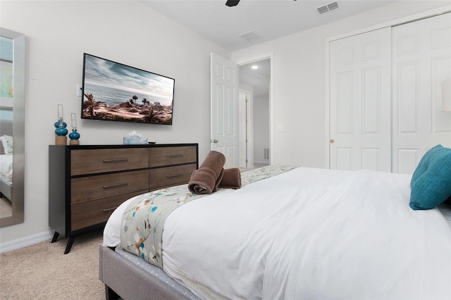 bedroom featuring a ceiling fan, visible vents, baseboards, a closet, and light colored carpet