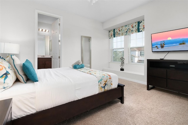 carpeted bedroom featuring baseboards and ensuite bathroom