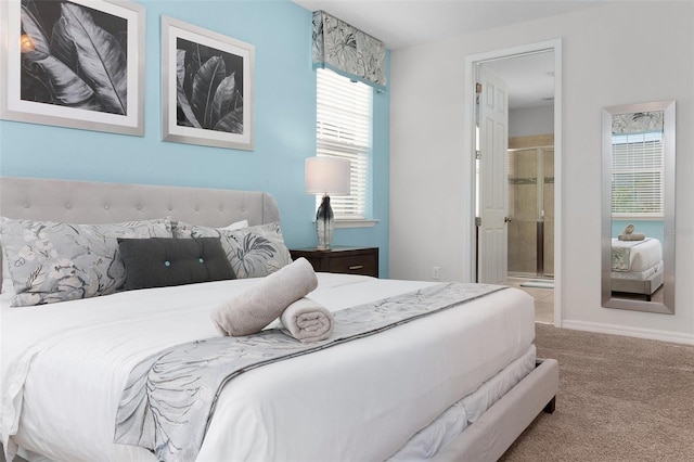 bedroom featuring baseboards, ensuite bathroom, and carpet