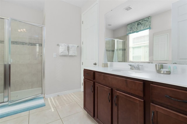 bathroom featuring tile patterned flooring, a shower with door, and vanity