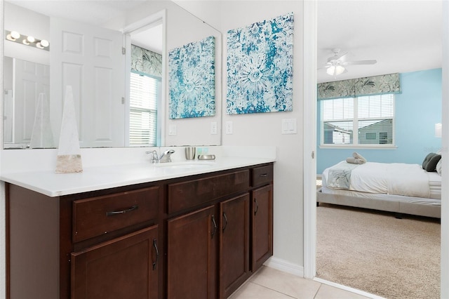 ensuite bathroom with tile patterned floors, connected bathroom, baseboards, ceiling fan, and vanity