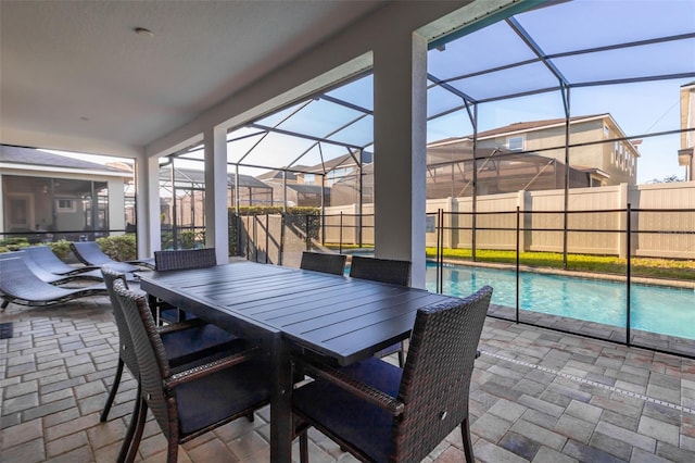 view of patio / terrace featuring glass enclosure, fence, outdoor dining area, and a fenced in pool