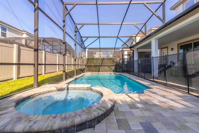 view of swimming pool with glass enclosure, a patio area, and an in ground hot tub