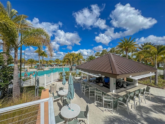 view of patio / terrace with a gazebo, a community pool, and fence