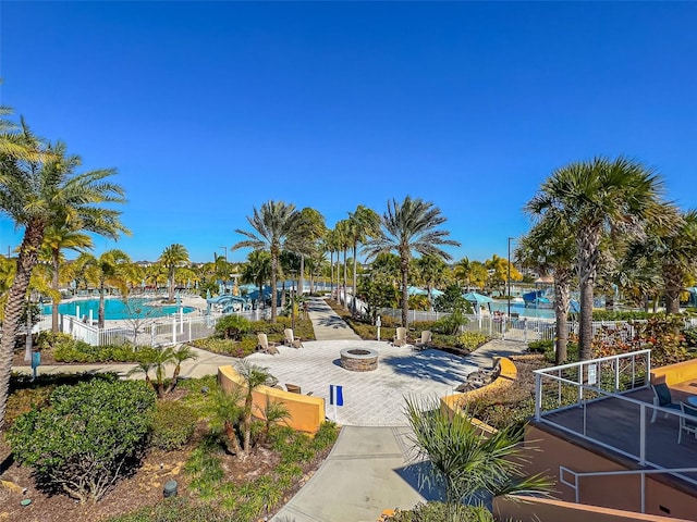 surrounding community with a pool, a fire pit, and fence