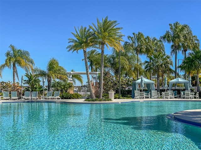 community pool with a gazebo, fence, and a patio