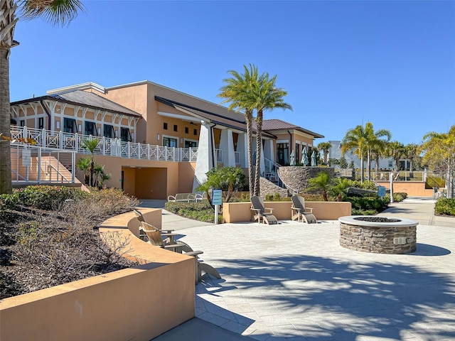 surrounding community featuring a patio area and a fire pit