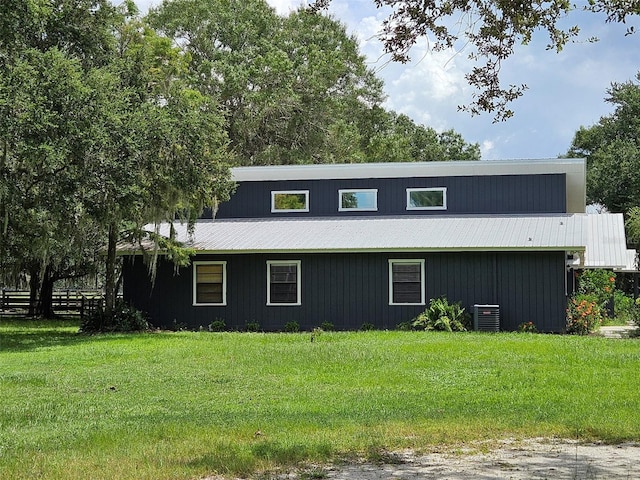 view of front of property featuring a front lawn and cooling unit