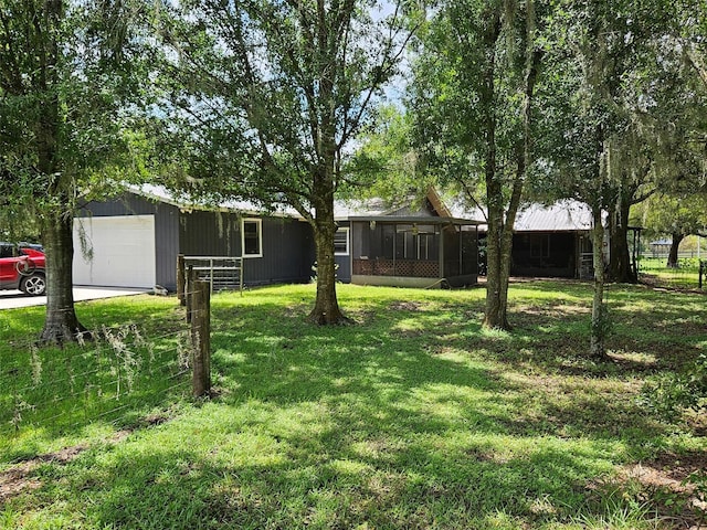 view of yard with a garage and a sunroom